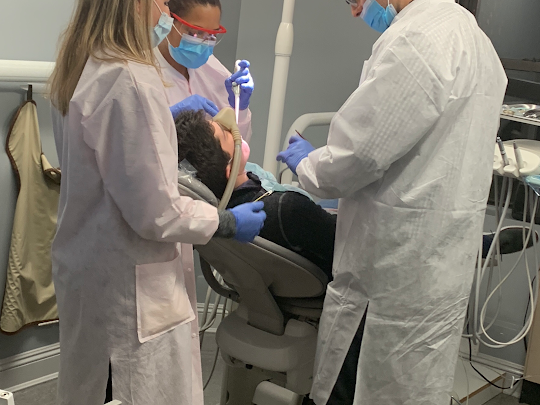 arafed man and woman in white lab coats and masks are looking at a patient