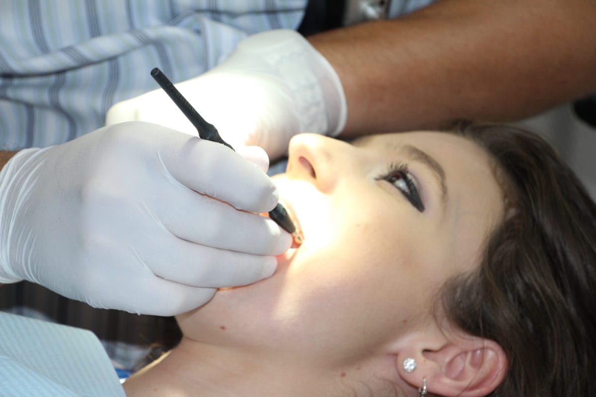 arafed woman getting her teeth examined by a dentist