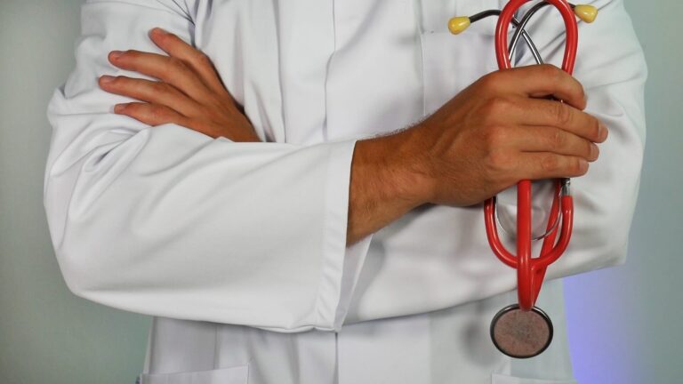 arafed male doctor in white coat holding a red stethoscope