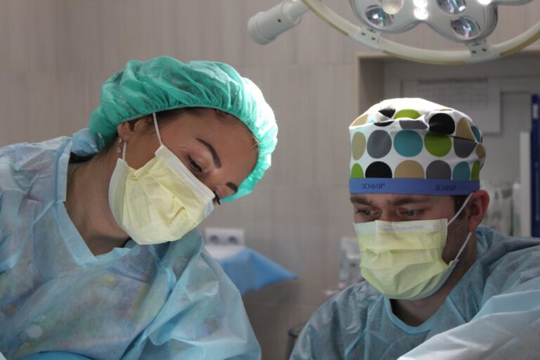 doctors in scrubs and masks are preparing to perform surgery