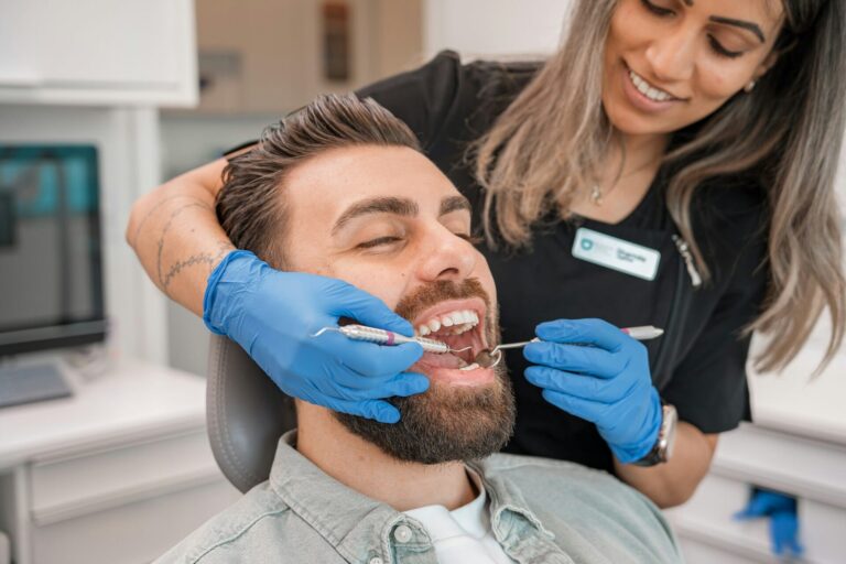 arafed man getting his teeth examined by a dentist