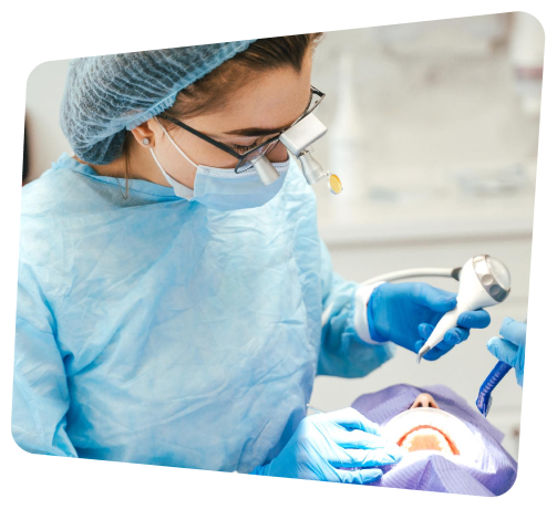 arafed woman in blue gown and mask operating a dental device