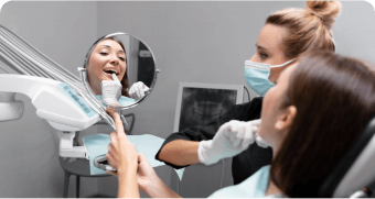 woman in a dental chair getting her teeth brushed by a dentist