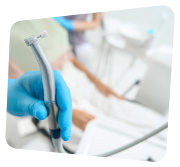 a close up of a person in a blue glove holding a dental device