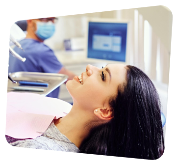 a woman sitting in a chair with a dentist in the background