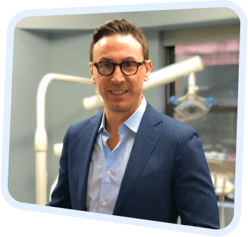 a close up of a man in a suit and glasses in a dental room