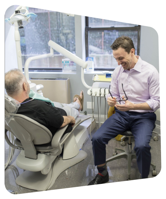 arafed man sitting in a chair with a patient in a dental room