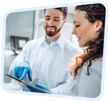 a man and woman in lab coats looking at a tablet