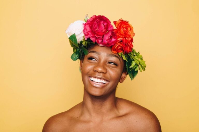 arafed woman with a flower crown on her head smiling