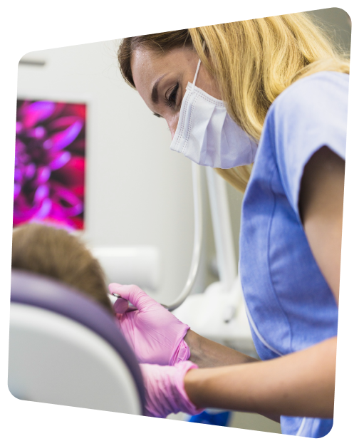 arafed woman in a blue shirt and purple gloves is getting her teeth brushed