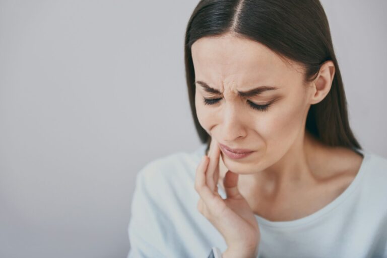 a woman with a toothache holding her hand to her face