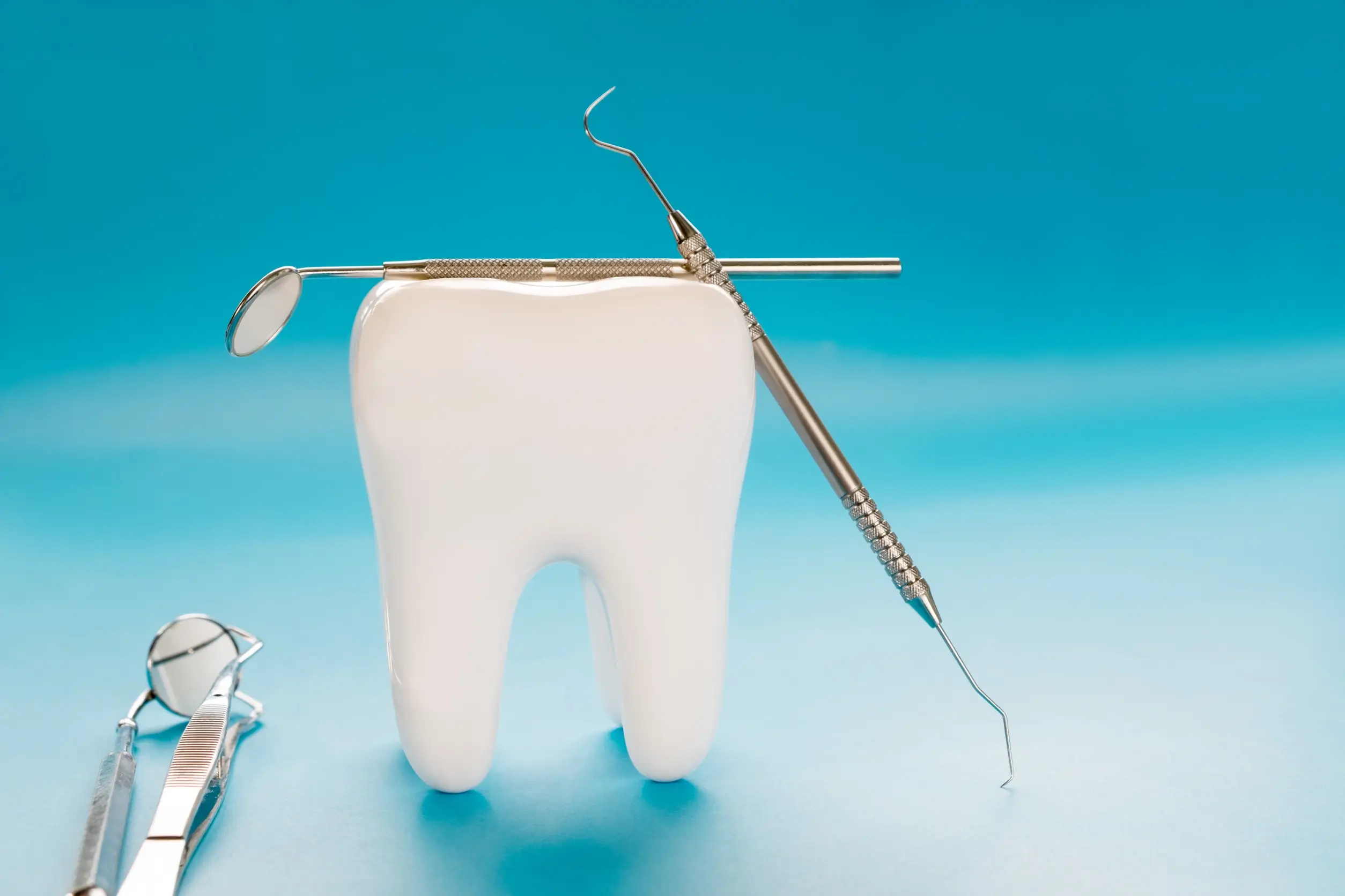 there is a toothbrush and a dental instrument on a blue surface
