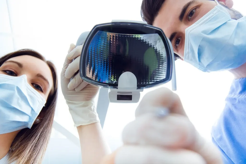 arafed dentists in scrubs and masks are looking at a mirror