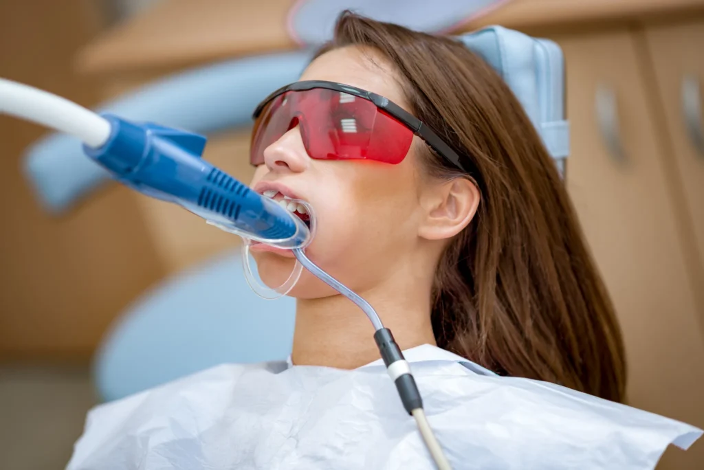close-up-beautiful-young-woman-visit-dentist-office-whitening-teeth-with-ultraviolet-light